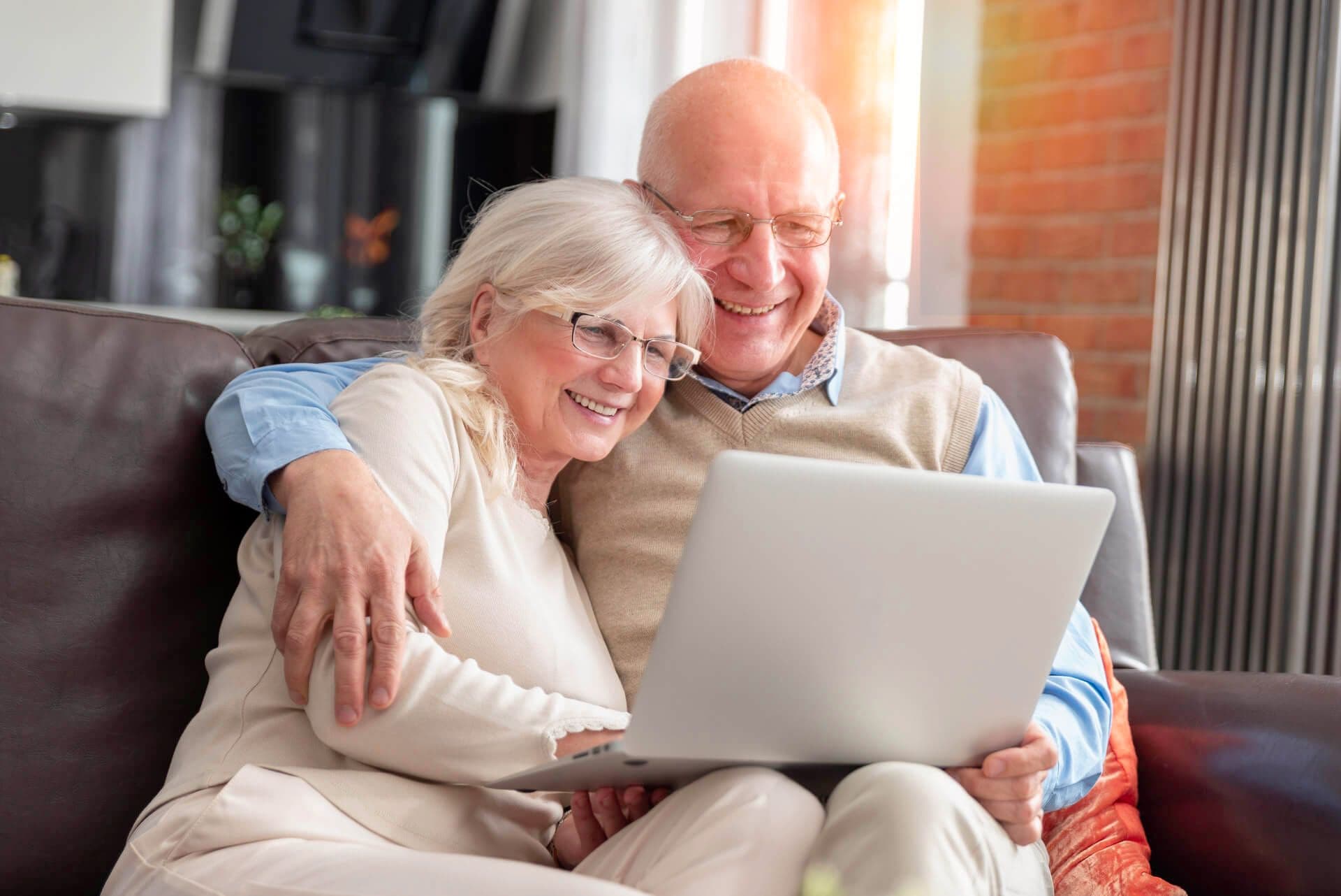 Older couple smiling at laptop