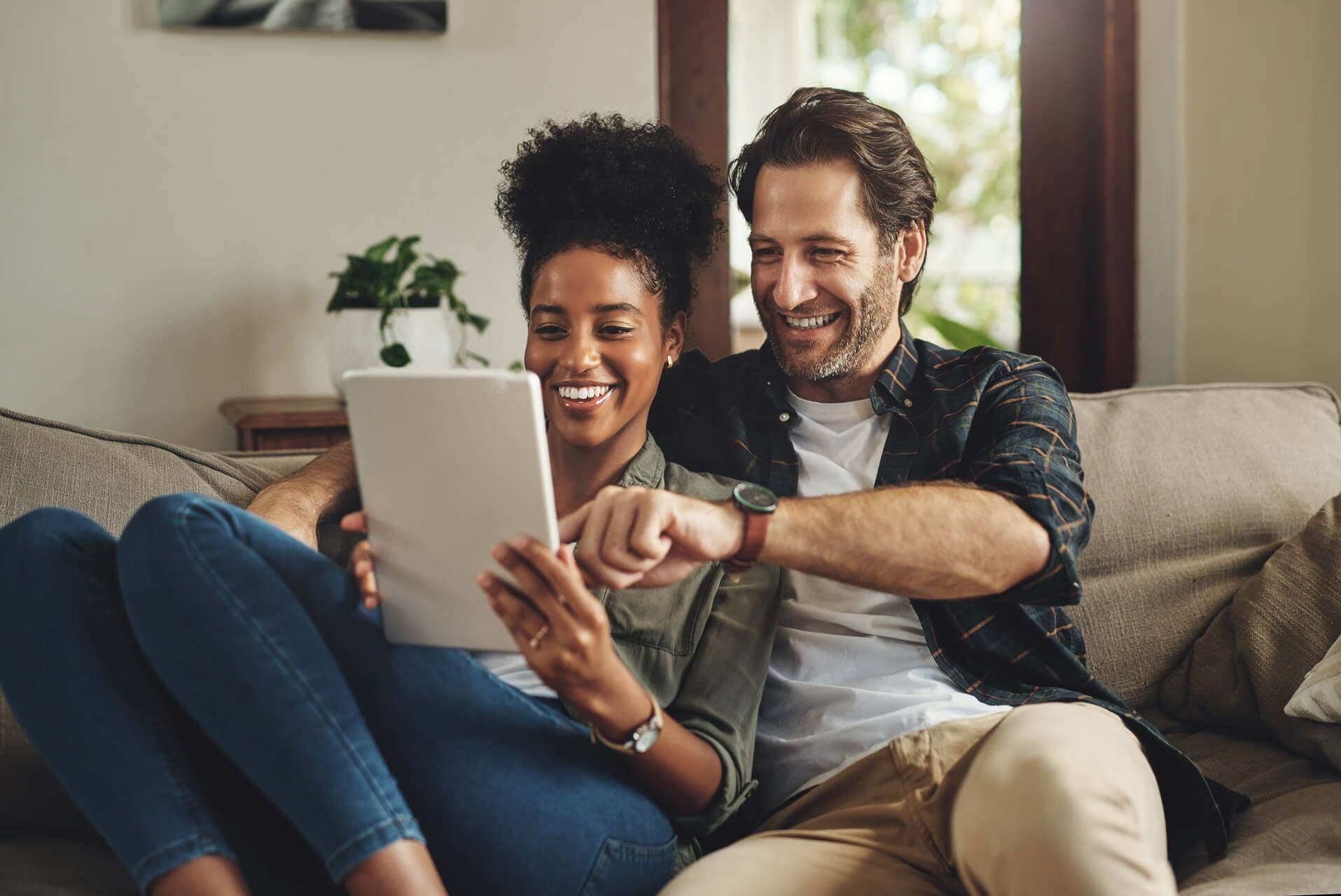 Couple smiling and looking at a tablet