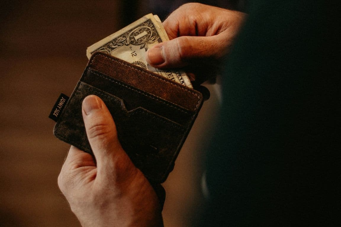 A person takes cash out of their wallet.