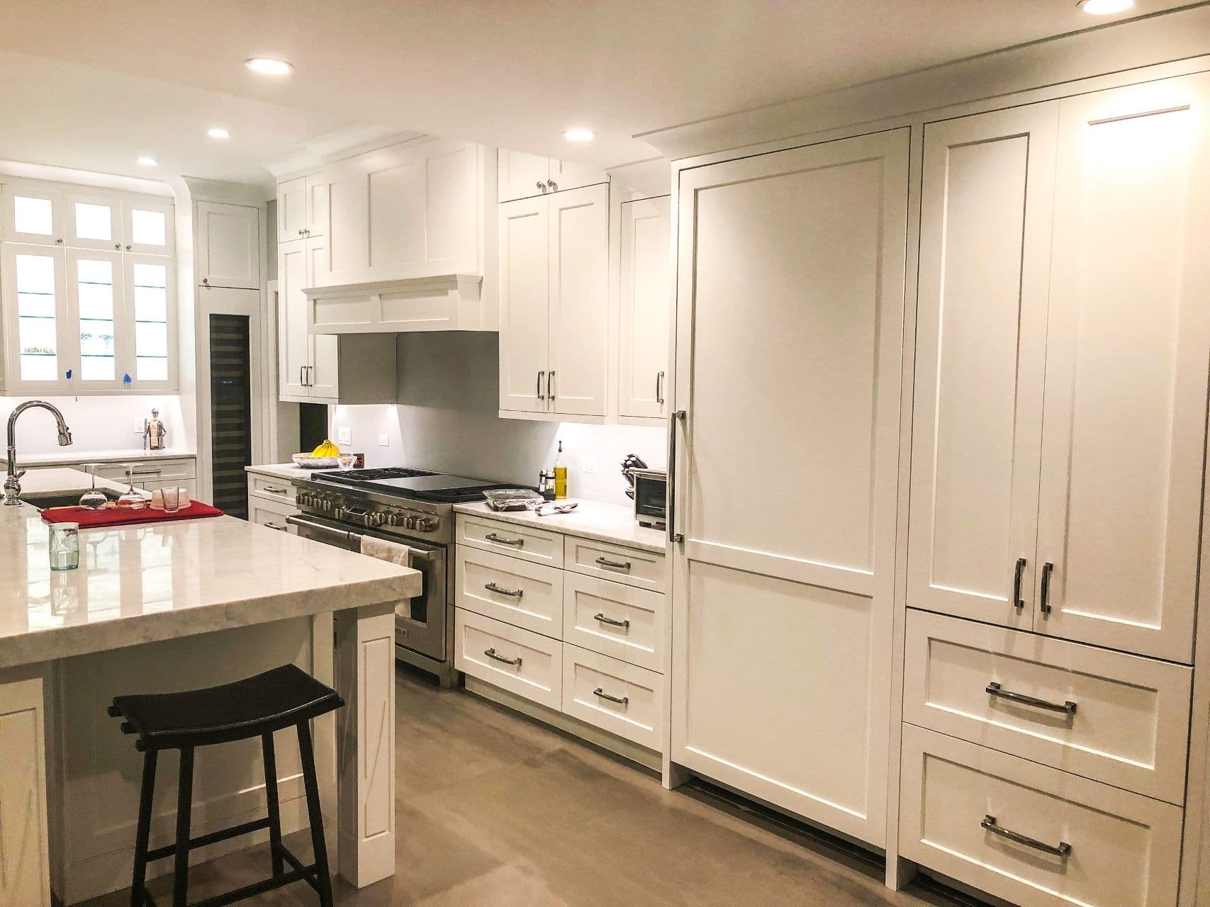 A kitchen with white cabinets and an island countertop.